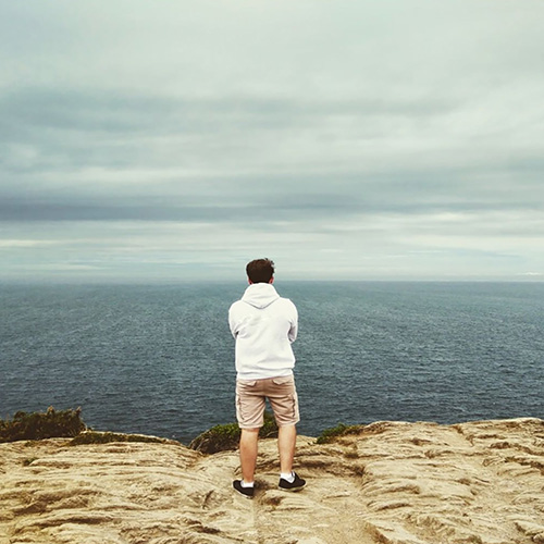 Photographie de Sébastien de dos sur une falaise